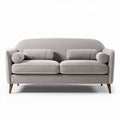 Two-seater upholstered sofa in light gray with wooden legs and throw pillows